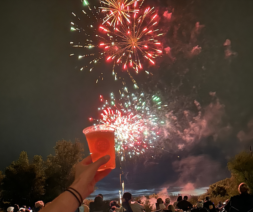 beer in front of a massive firework display for Independence Day